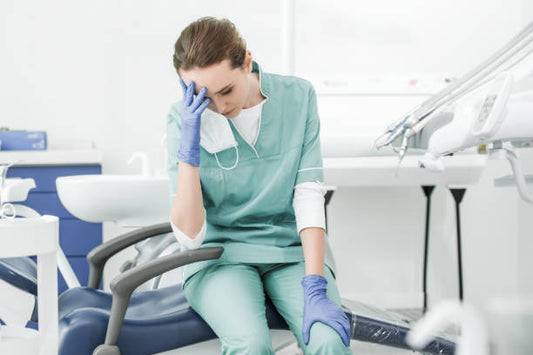 Image shows a stressed and tired dentist